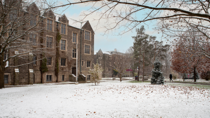 snow covering the ground surrounded by historic buildings on campus