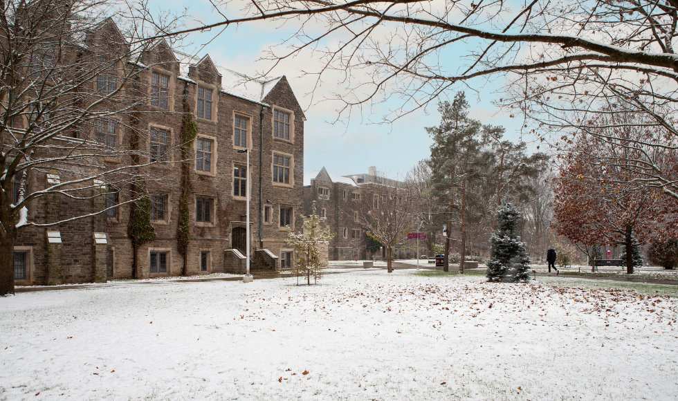 snow covering the ground surrounded by historic buildings on campus